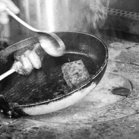 Lamb being pan-fried on industrial hob